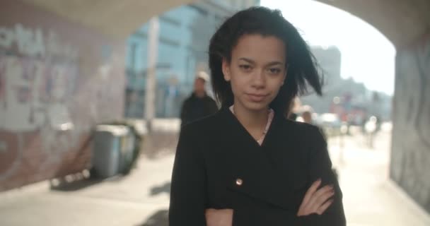 Portret van jonge African American vrouw op zoek naar een camera, buitenshuis. — Stockvideo