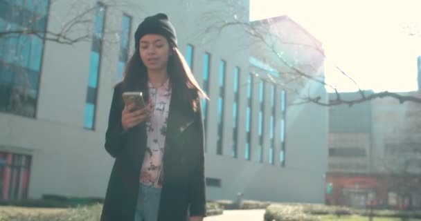 Retrato de una joven afroamericana usando teléfono, al aire libre . — Vídeos de Stock