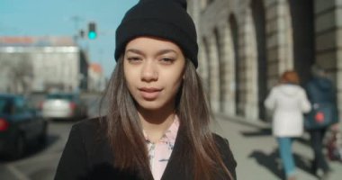 Açık havada bir kamera için arayan genç Afro-Amerikan kadın portresi.