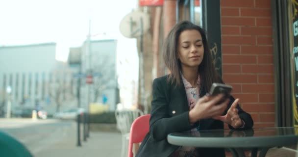 Retrato de una joven afroamericana usando teléfono, al aire libre . — Vídeo de stock