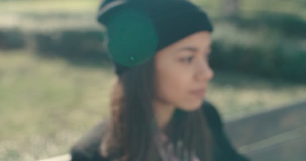 Young beautiful african american woman sitting on a bench. — Stock Video