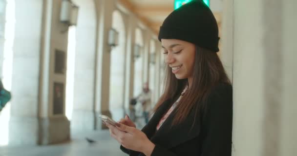 Retrato de una joven afroamericana usando teléfono, al aire libre . — Vídeo de stock