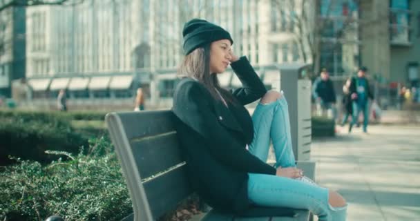 Young beautiful african american woman sitting on a bench. — Stock Video