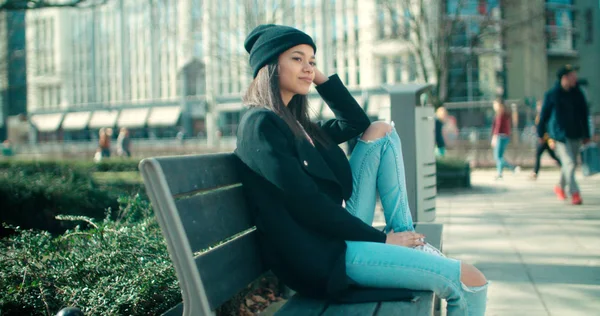 Young beautiful African American woman sitting on a bench. — Stock Photo, Image