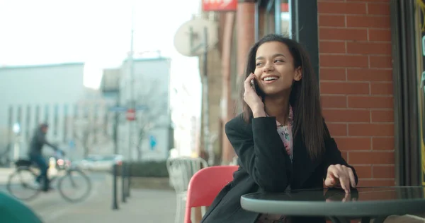 Retrato de una joven afroamericana usando teléfono, al aire libre . — Foto de Stock