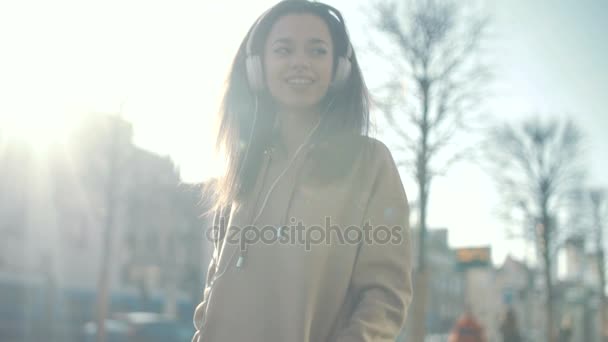 Jonge vrouw met hoofdtelefoon genieten van tijd in een stad. — Stockvideo