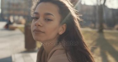 Şık kadın rahatlatıcı bir şehir parkı güneşli gün boyunca.