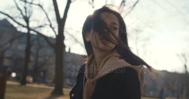 Şık kadın rahatlatıcı bir şehir parkı güneşli gün boyunca.