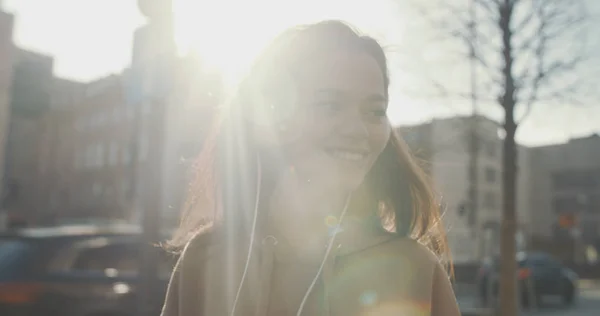 Mujer joven con auriculares disfrutando del tiempo en una ciudad . — Foto de Stock