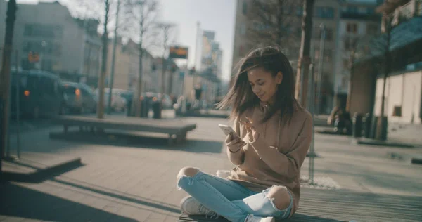 Retrato de una joven afroamericana usando teléfono, al aire libre . — Foto de Stock