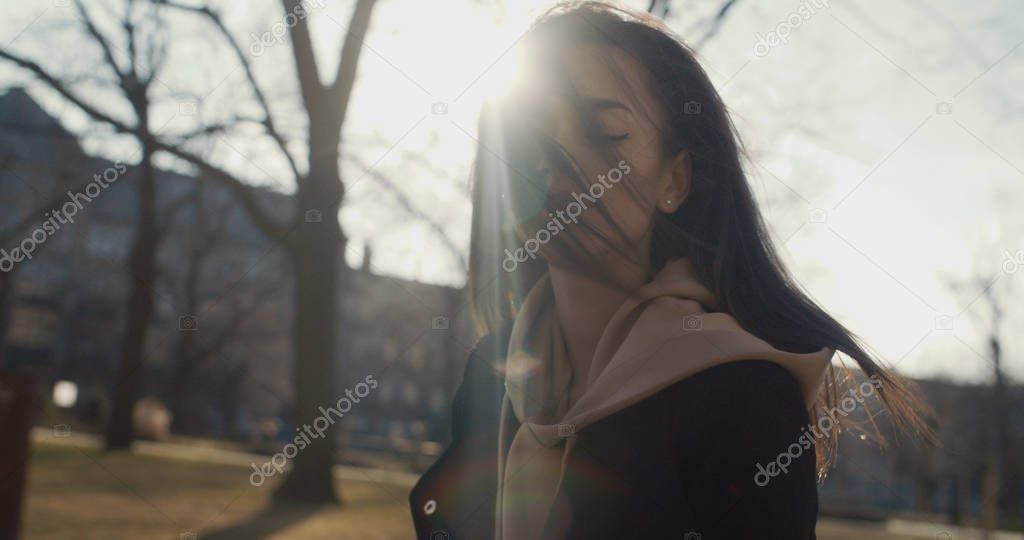 Stylish woman relaxing in a city park during sunny day.