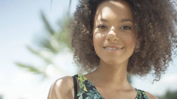 Mujer joven posando ante una cámara y sonriendo . — Foto de Stock