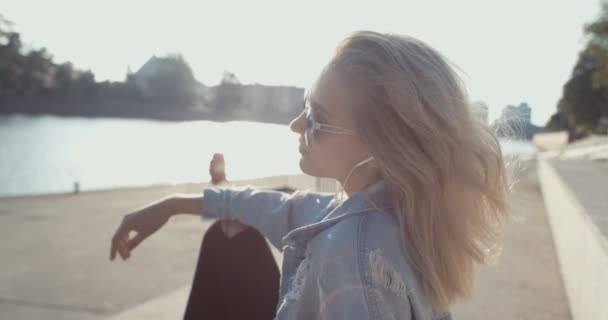 Mujer joven con auriculares disfrutando del tiempo en una ciudad . — Vídeo de stock