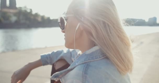 Mujer joven con auriculares disfrutando del tiempo en una ciudad . — Vídeos de Stock