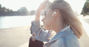 Genç kadın bir şehirde vaktinizi kulaklıklar ile.