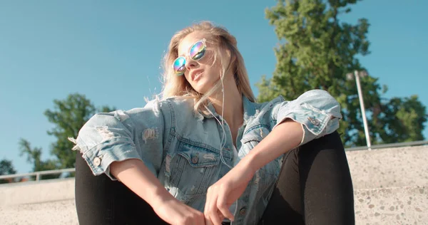 Jeune femme avec écouteurs profiter du temps dans une ville . — Photo