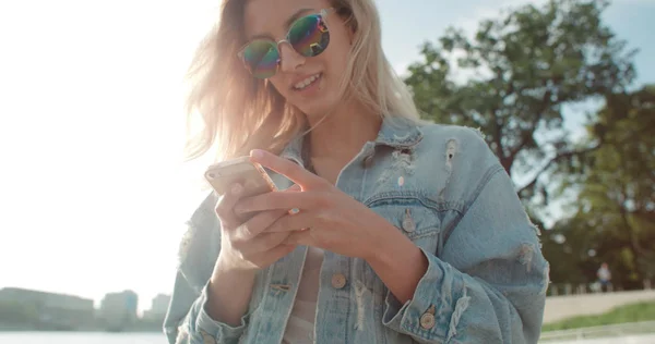 Mujer rubia joven usando el teléfono en una ciudad . —  Fotos de Stock