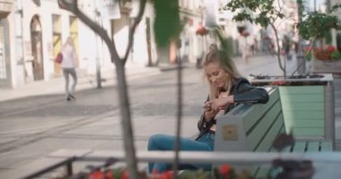 Telefon bir şehirde kullanan genç beyaz kadın.