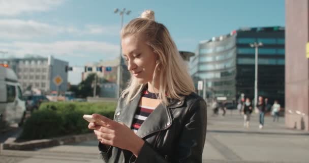Jovem caucasiana usando telefone em uma cidade . — Vídeo de Stock