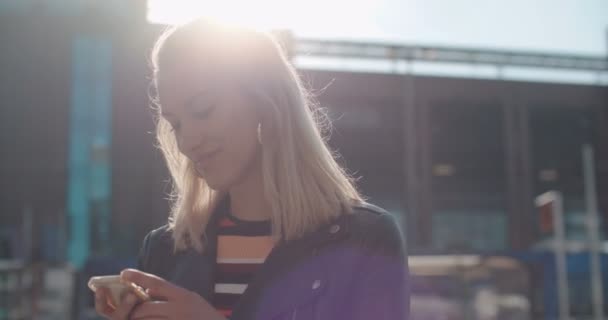 Joven mujer caucásica usando el teléfono en una ciudad . — Vídeo de stock