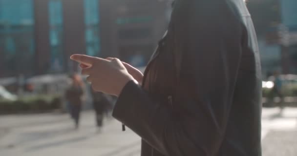 Young caucasian woman using phone in a city. — Stock Video