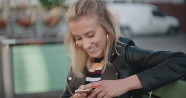 Молода біла жінка використовує телефон у місті . — стокове відео