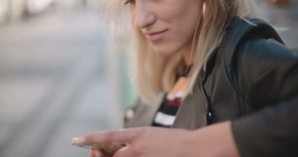 Joven mujer caucásica usando el teléfono en una ciudad . — Vídeos de Stock