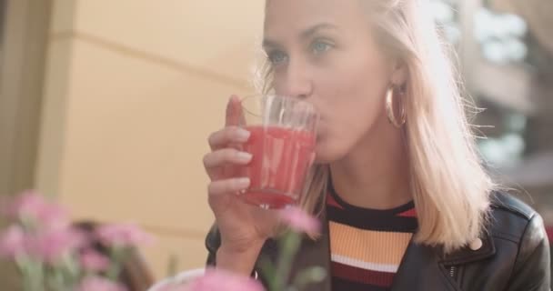 Bella ragazza caucasica seduta al caffè e bere succo di frutta . — Video Stock