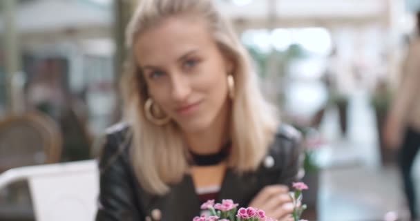 Красивая молодая кавказская девушка сидит в кафе и улыбается . — стоковое видео