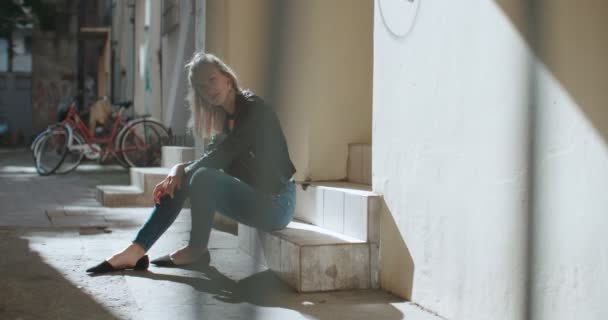 Pretty fashion woman sitting on stairs. — Stock Video