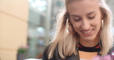 Telefon bir şehirde kullanan genç beyaz kadın.