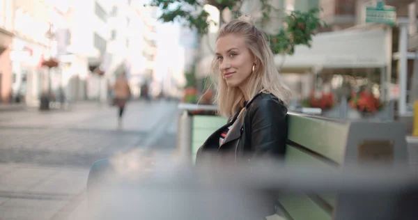 Beautiful woman sitting on bench and waiting for a date. — Stock Photo, Image