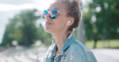 Genç kadın bir şehirde vaktinizi kulaklıklar ile.