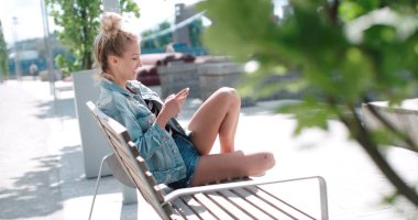 Telefon bir şehir parkında kullanan oldukça beyaz kız.