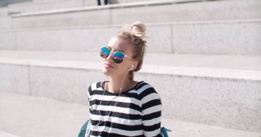 Genç kadın bir şehirde vaktinizi kulaklıklar ile.