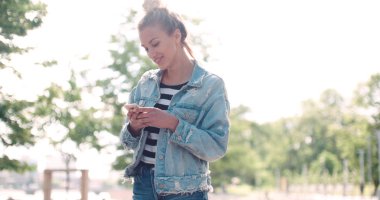 Telefon bir şehir parkında kullanan oldukça beyaz kız.