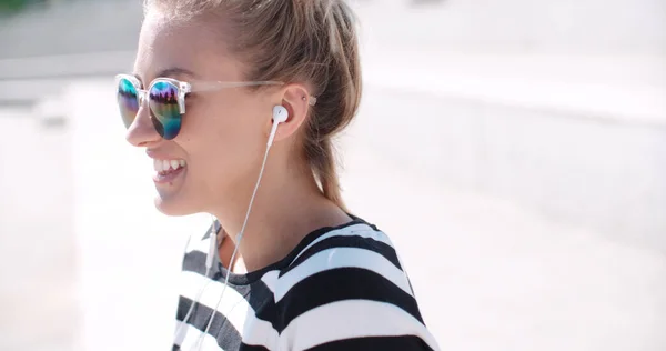 Mujer joven con auriculares disfrutando del tiempo en una ciudad . —  Fotos de Stock