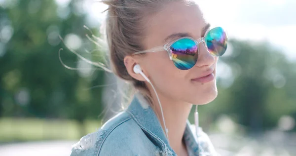 Mujer joven con auriculares disfrutando del tiempo en una ciudad . — Foto de Stock