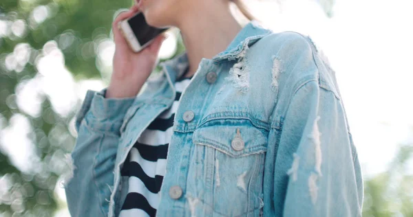 Όμορφη νεαρή γυναίκα που μιλάει στο τηλέφωνο κατά τη διάρκεια της ηλιόλουστη μέρα. — Φωτογραφία Αρχείου