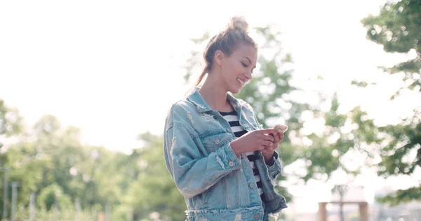 かなり白人の女の子は都市公園における携帯電話を使用して. — ストック写真