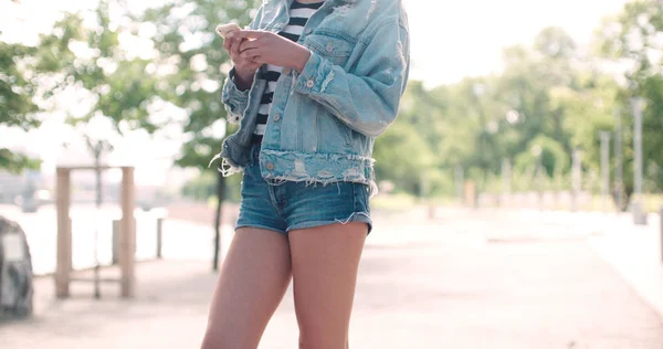 携帯電話を屋外で使う若い女性の手のクローズ アップ. — ストック写真