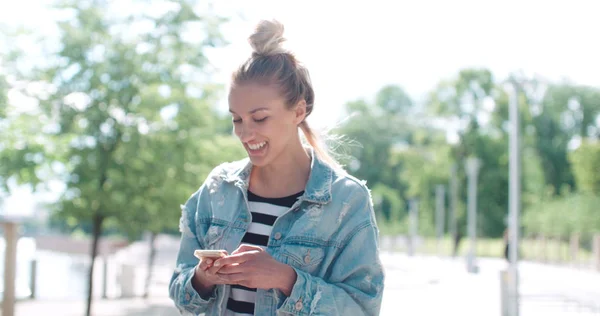 Menina muito caucasiana usando telefone em um parque da cidade . — Fotografia de Stock