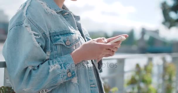 Gros plan de jeunes mains féminines utilisant le téléphone, à l'extérieur . — Video