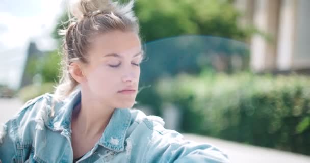 Щаслива стильна дівчина в джинсовій куртці насолоджується своїм часом під час сонячного дня . — стокове відео