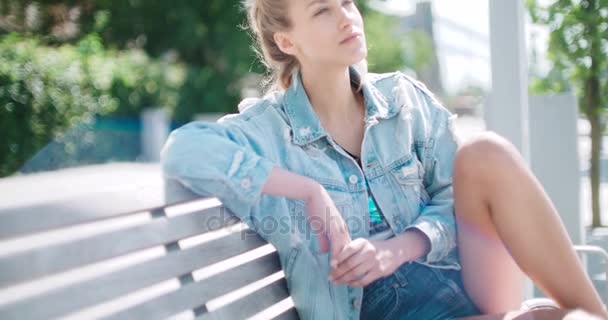 Glad snygg tjej bär jeansjacka åtnjuter hennes tid under solig dag. — Stockvideo