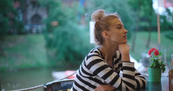 Θλιβερή αρκετά Καυκάσιος κορίτσι κάθονται στο καφενείο σε εξωτερικούς χώρους και να περιμένει κάποιος. — Αρχείο Βίντεο