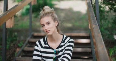 Bir kameraya bakarak ve gülümseyen güzel sarışın kız.