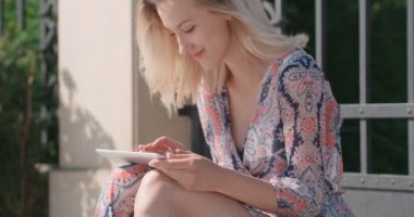 Genç güzel sarışın kadın bir şehirde sokak dijital tablet kullanma.