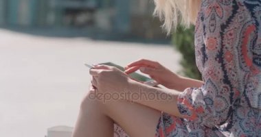 Genç güzel sarışın kadın bir şehirde sokak dijital tablet kullanma.