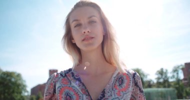 Genç kadın kameraya bakıyor ve gülümsüyor.. 